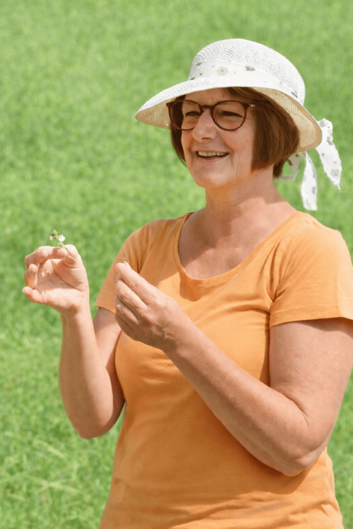 Kräuterpädagogin erklärt heimische Wildkräuter bei einer geführten Kräuterwanderung in der Natur